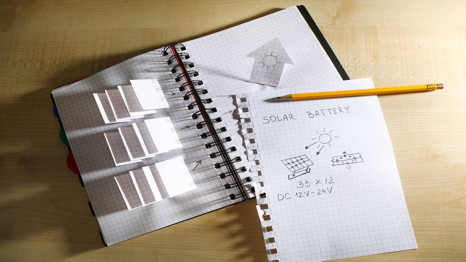 A notebook with iterative sketches showing progression from rough concept to refined design across multiple pages